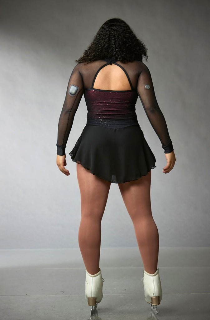 Black and red one-of-a-kind figure skating dress for women, featuring crystals and mesh sleeves, Zaza model, back view – EliteXpression
Robe patinage artistique unique noire et rouge pour femmes, ornée de pierres, avec des manches longues en mesh, modèle Zaza, vue de dos – EliteXpression