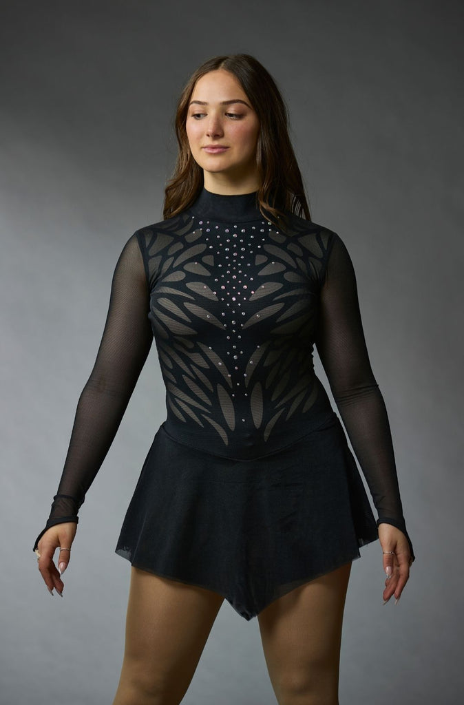 Black figure skating dress for women, featuring crystals and mesh sleeves, Candy model, front view – EliteXpression
Robe patinage artistique noire pour femmes, ornée de pierres, avec des manches longues en mesh, modèle Candy, vue de face – EliteXpression
D242B-BK