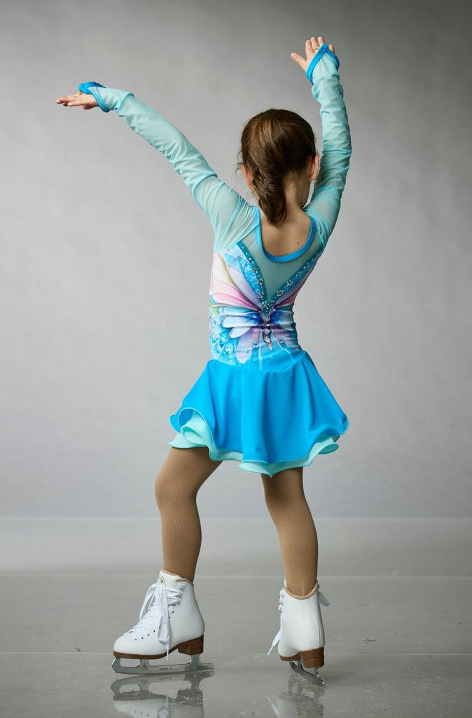 Young girl wearing a teal and blue long-sleeve figure skating dress featuring a butterfly design, purple-pink details, and crystal embellishments, model Butterfly, back view – EliteXpression
Jeune fille qui porte une robe de patinage artistique bleue et turquoise avec des manches longues, un design de papillon, des détails rose-mauve, et ornée de cristaux, modèle Butterfly (Papillon), vue de dos – Elite Xpression
D440-BUTBLU