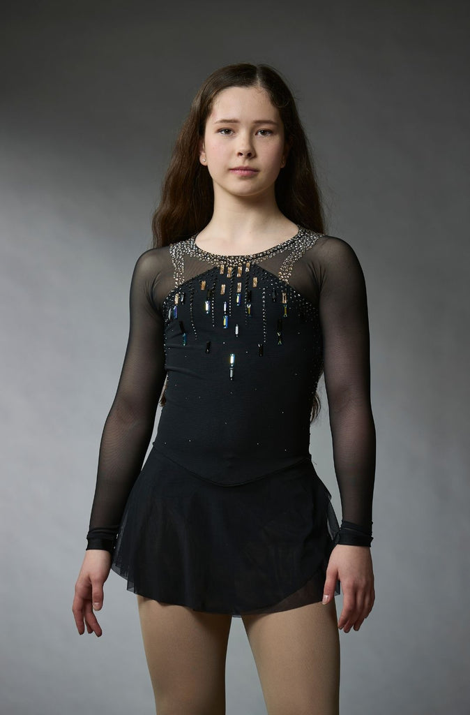 One-of-a-kind black figure skating competition dress with crystal-embellished bodice in gold, black, and graphite, open mesh back, long mesh sleeves, and double-layered mesh skirt, model Sabrina, front view – EliteXpression
Robe de compétition de patinage artistique noire unique avec corsage orné de cristaux dorés, noirs et graphite, dos ouvert en mesh, manches longues en mesh et jupe en mesh à double couche, modèle Sabrina, vue de face – EliteXpression